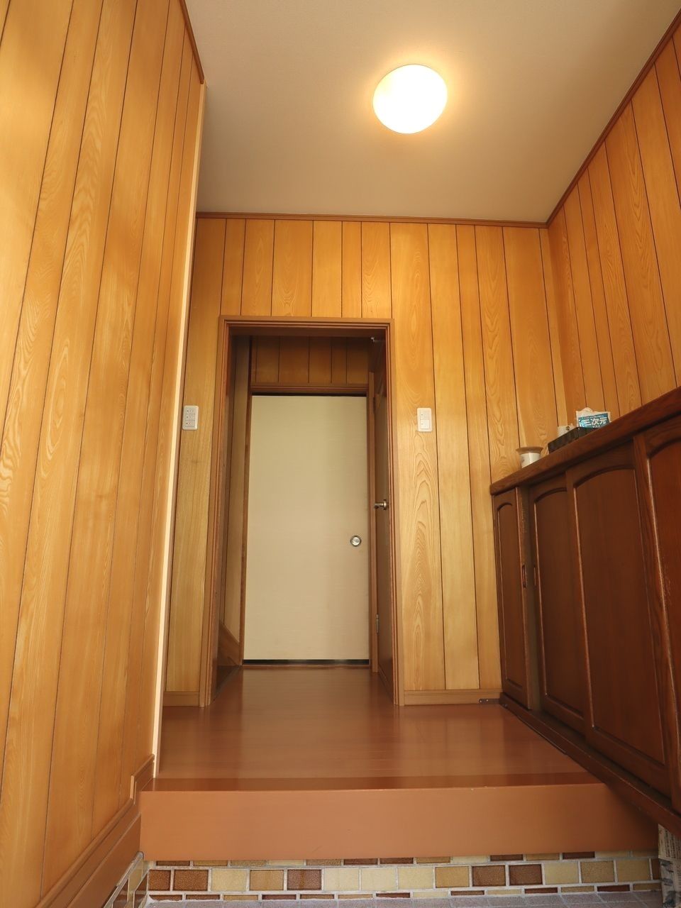 木目の美しい板張りの壁で木のぬくもりを感じられる玄関ホール